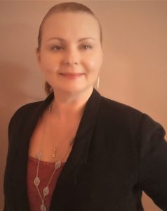 Woman wearing a black blazer and long necklace
